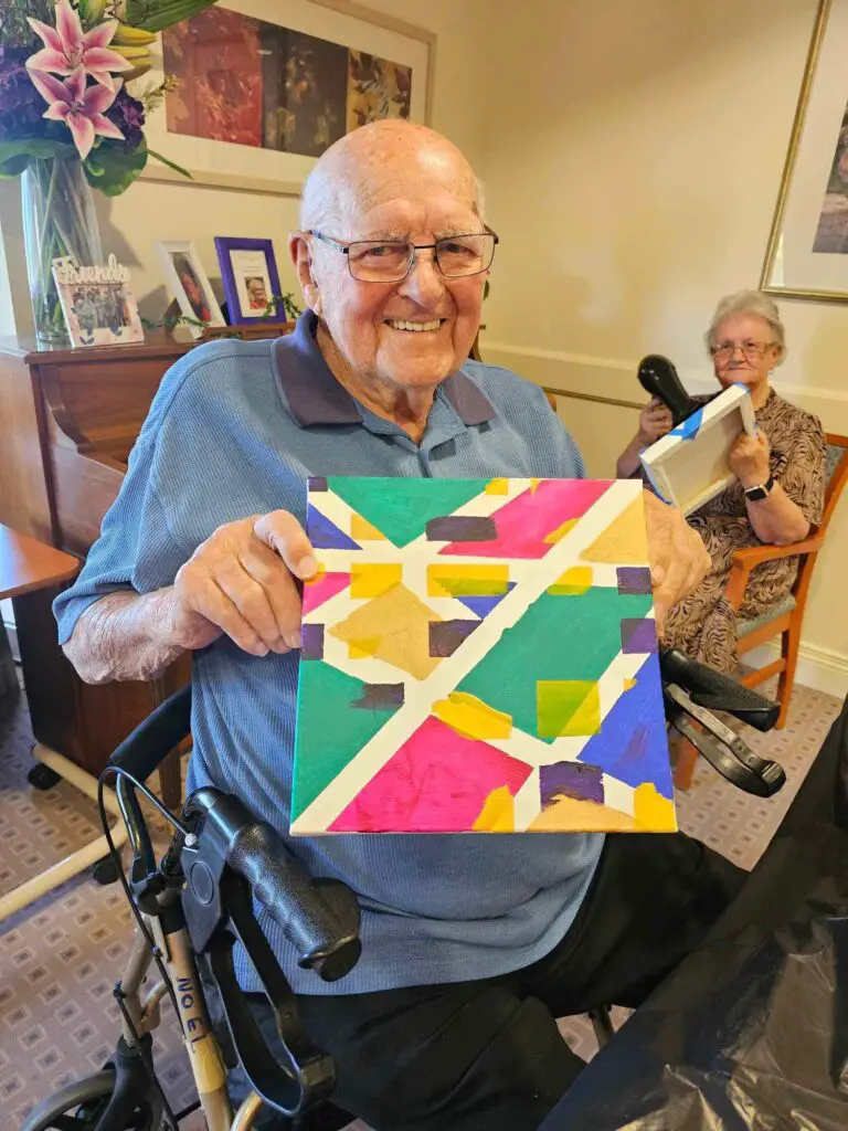 elderly man holding painting